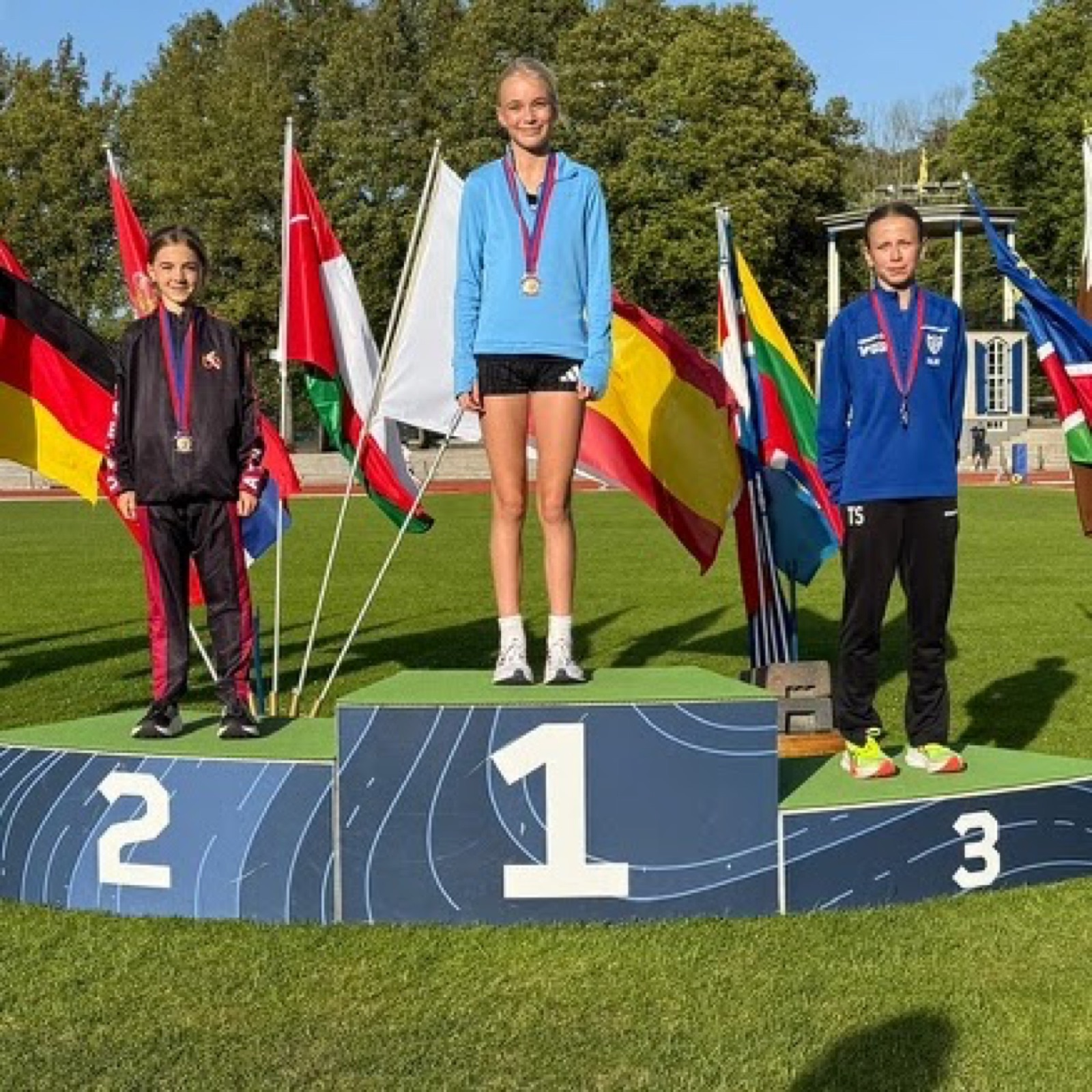 Medal ceremony with flags: Carla on the second step of the podium