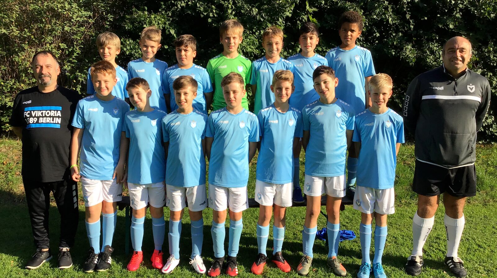 Young Viktoria Berlin team in light blue kits with coaches